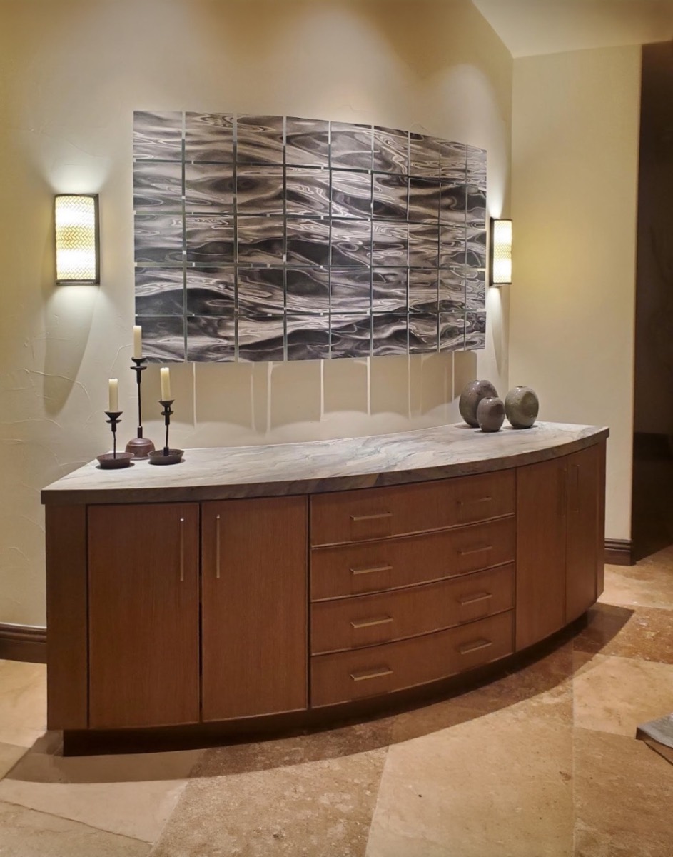 Multi-panel wave drawing mounted across a curved plaster wall above a custom credenza