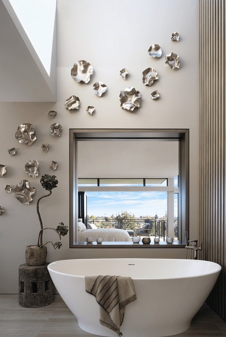 Silver sculptural wall installation above a freestanding tub