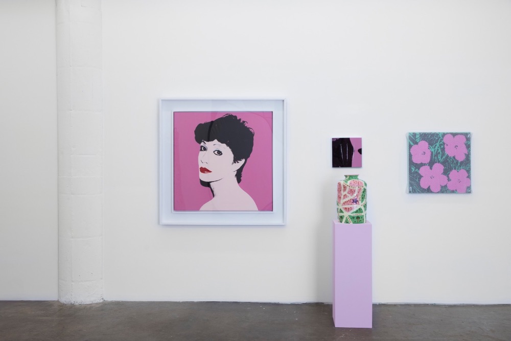 Bold pop-art portrait hung beside ceramics on pedestals