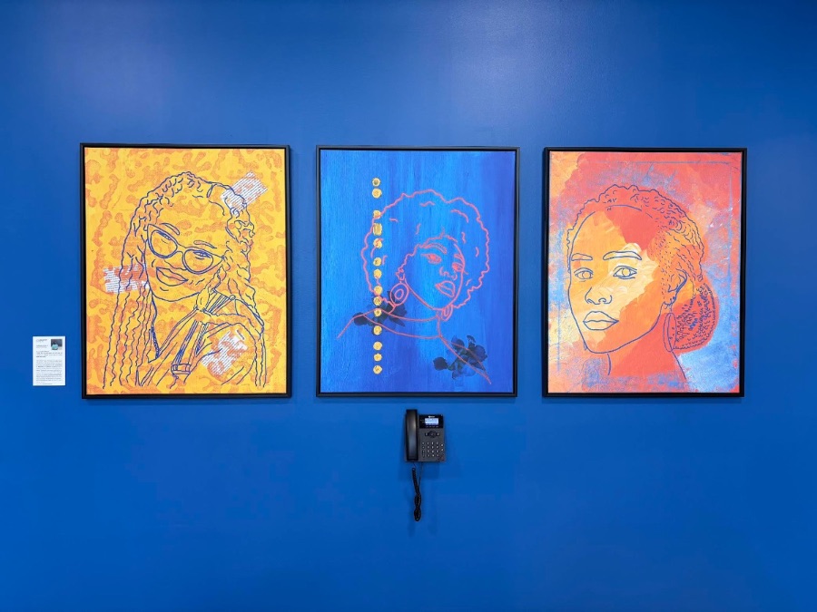Three line-drawn portraits on a cobalt office wall