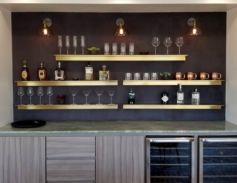 Custom brass bar shelving with glassware and spirits