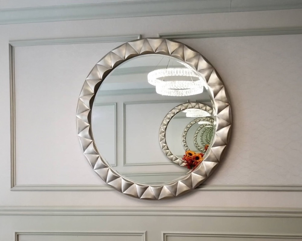 Ornate round mirror mounted on a paneled wall by the install crew